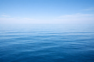 Obraz premium Peaceful ocean surface with clear horizon under blue sky, minimal seascape background ideal for calm, nature and meditation themes.