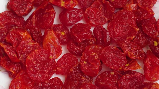 Close-up of dried pitted cherries spread on a white background. Bright red dehydrated berries rich in vitamins for healthy eating and culinary use