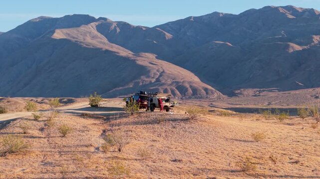 View aerial shots of camper and SUV traveling along thimble trail in Anza Borego Desert State Park, California during daylight hours.