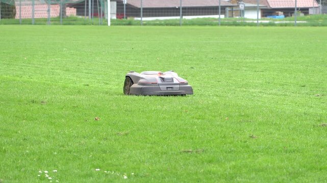 Ein M&auml;hroboter f&auml;hrt &uuml;ber eine gr&uuml;ne Wiese