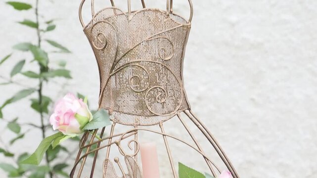 D&eacute;coration de mariage avec cage dor&eacute;e, roses et flacons en verre, ambiance romantique et &eacute;l&eacute;gante en ext&eacute;rieur