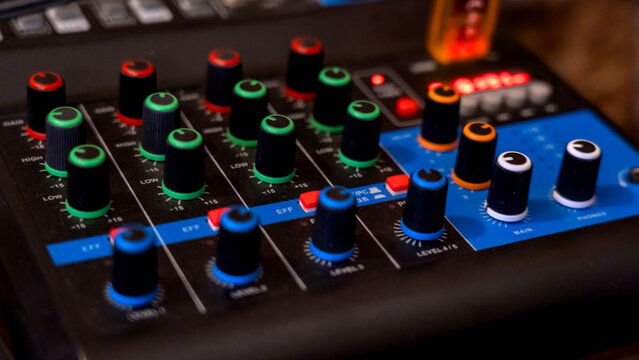 Close-up of audio mixer with colorful knobs and buttons