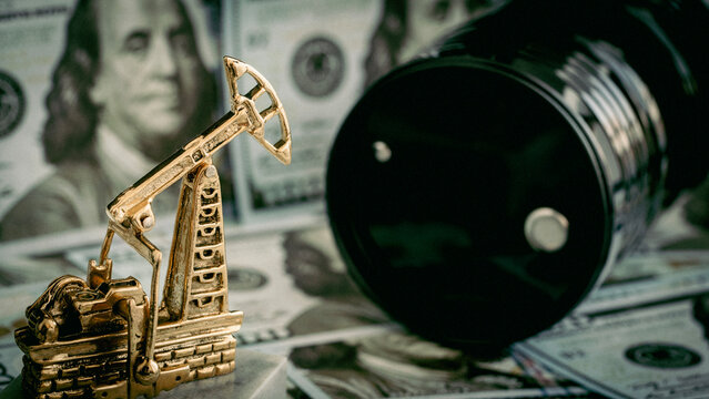 Golden oil pump stands on dollar bills