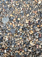Naklejka premium Top view of natural river pebbles and smooth colorful stones for background texture and garden design
