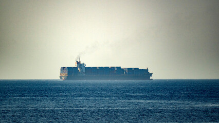 Obraz premium Massive cargo ship sails calm ocean waters