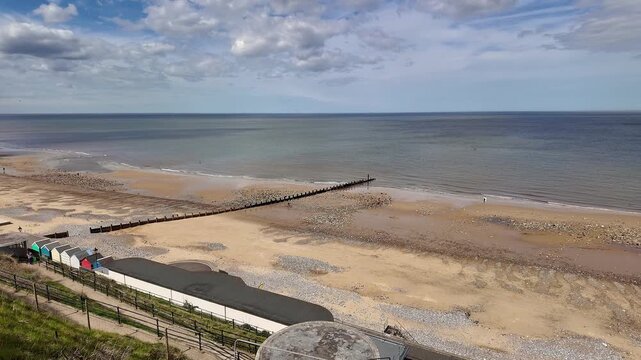 High up view over the sandy beach in the seaside town of Cromer on the North Norfolk coast. A sweeping panning shot.