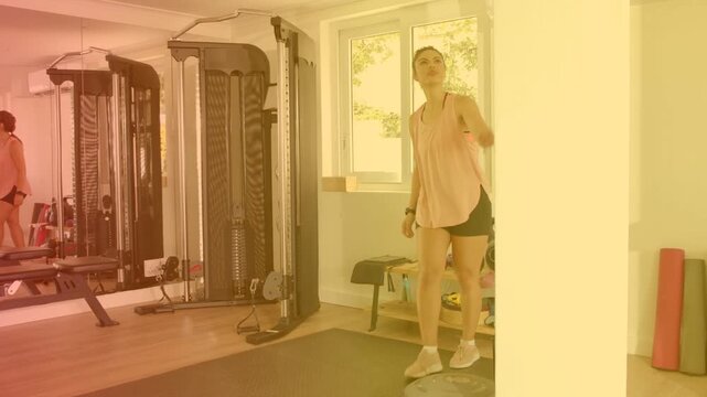 Woman checking phone, anchoring resistance band to pillar, pulling rows for strength training