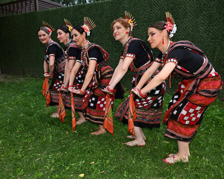 Five female dancers in colorful costumes dancing Indian dances in the park