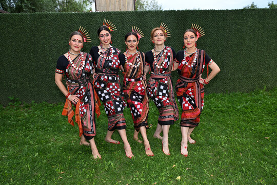 Five female dancers in colorful costumes dancing Indian dances in the park