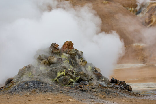 Large mound of rocks, fumarol with steam coming out of it, Hverir, Iceland, Namaskard, Hverarond big geothermal field next to Namafjall near Lake Myvatn