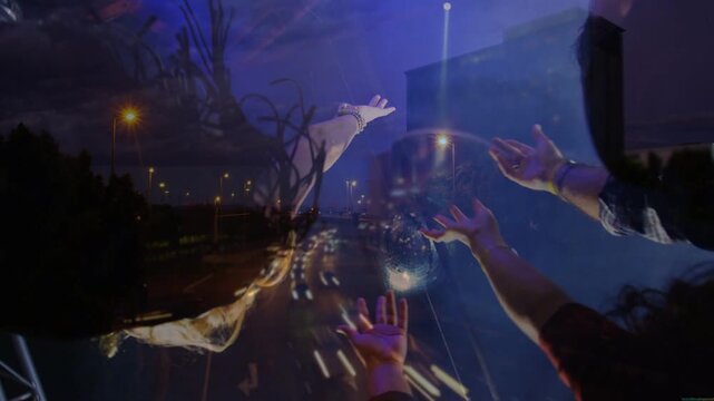 Spotlight hitting disco ball, crowd reaching for sphere as light streaking over hands during events