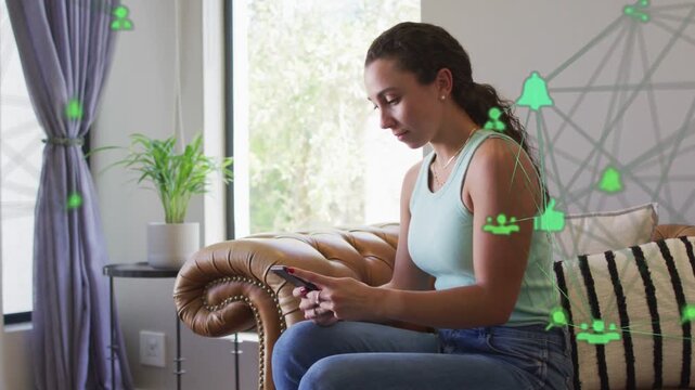 Woman on chaise tapping phone and scrolling social media, smiling as green-icon overlay hovering