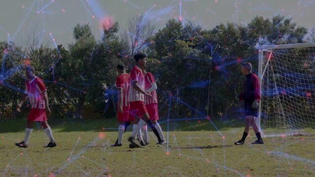 Defenders forming wall to block free kick at soccer goal, kicker striking, goalkeeper securing ball