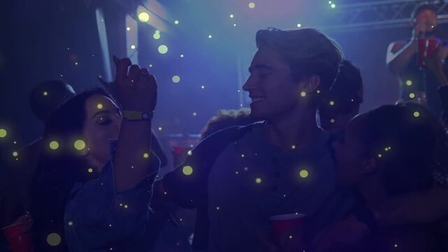 Man holding red cup arms around women, music singer raising mic spurring dancing under yellow dots