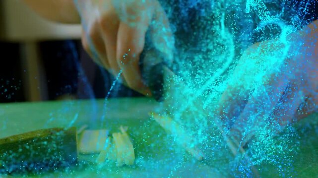 Cook's hand gripping knife, slicing veg on board, teal effect swirling over hands, prepping cuts