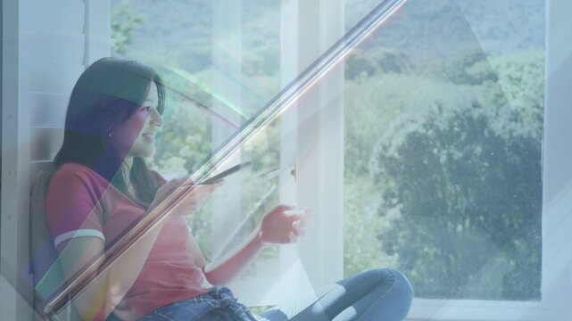 Teen girl reading text from social app while sitting on sill, prism overlay passing over sitter