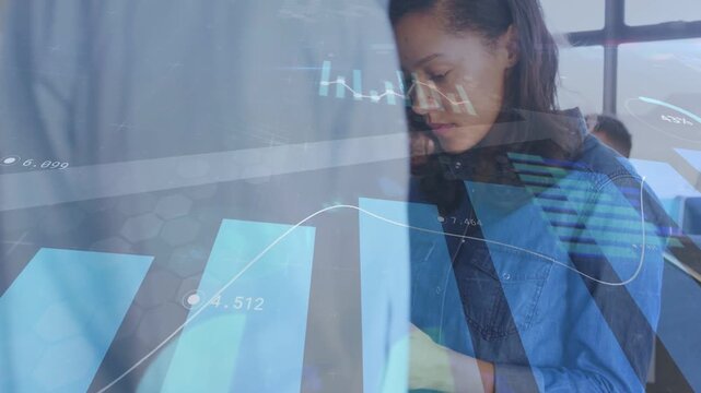 Woman in blue tapping tablet and initiating analysis, animated charts overlaying office coworkers