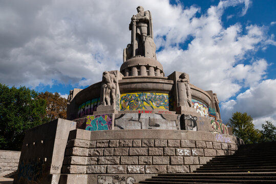 HAMBURG, GERMANY - SEPTEMBER 5, 2025: A low-angle view of the massive Bismarck Monument in Alter Elbpark, showing granite sculptures and vibrant modern graffiti against a cloudy sky