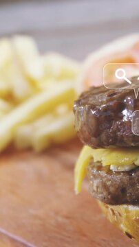 Vertical video: Rising bubbles from left for likes, double burger with cheddar on board, copy space