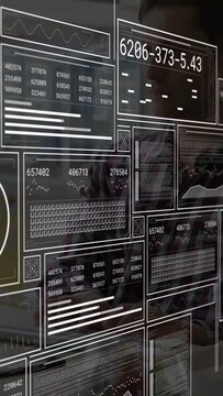 Vertical video: Analyst typing at glass keys causing HUD panels scrolling revealing data for review