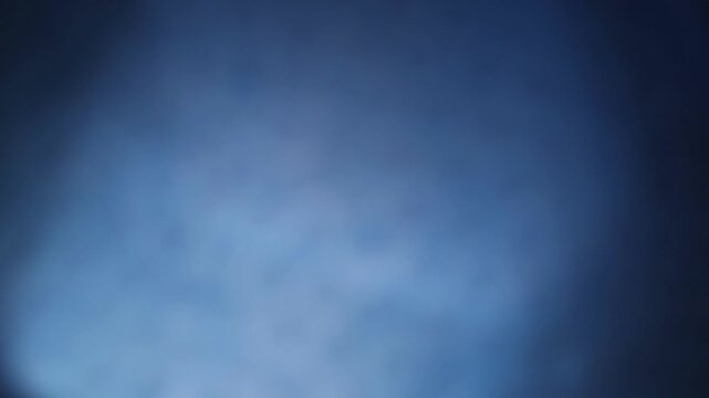 Una toma de cerca de un fondo abstracto de color azul con negro un degradado ligero desenfocado en movimiento. 