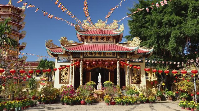 Beautiful view of Loc Tho Buddhist pagoda architecture in Nha Trang, Vietnam. Traditional temple decorated with red lanterns and flags for lunar new year celebration. Asian religious landmark.