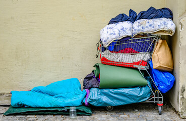 Stacked blankets and bedding in a shopping cart near a wall in an urban area during the day © fottoo