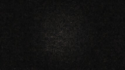 Fototapeta premium A dark grainy texture with subtle digital noise and a soft central highlight. This atmospheric background is ideal for cinematic titles