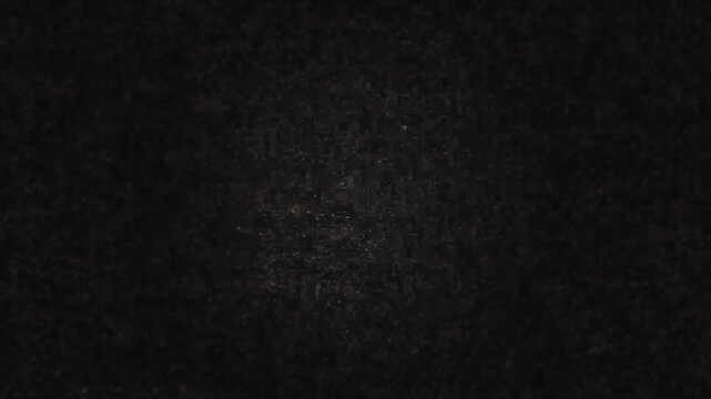 A dark grainy texture with subtle digital noise and a soft central highlight. This atmospheric background is ideal for cinematic titles