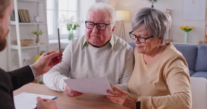 Senior elderly couple and agent signing document contract discussing terms, serious discussion for legal process, consultant interacting with old clients, managing health insurance plan, medicare 