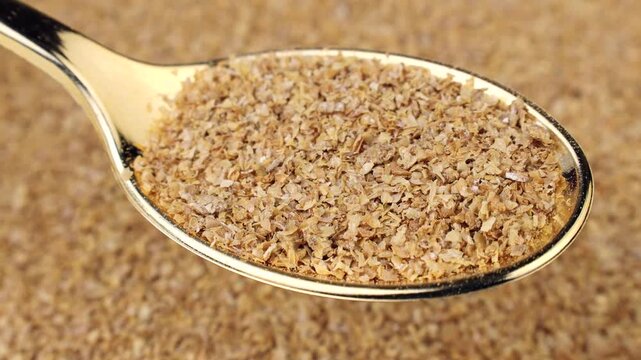 Organic Wheat Bran flakes in the spoon with background circle rotation close up