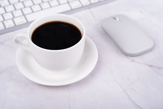 Cup of coffee and computer mouse on a desk