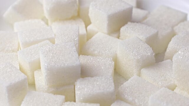 White sugar cubes falling down close up