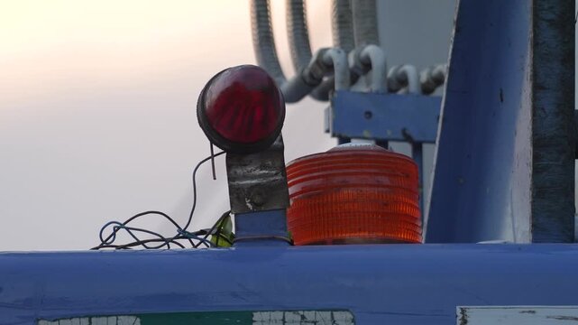 Close-up at flash warning light bulb of construction crane during it operating or lifting heavy object. Safety signal of heavy machine equipment.