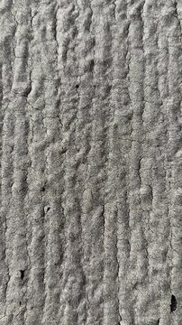 Uniflex rolled roofing closeup texture revealing granular asphalt surface with gritty granules, weathered bubbles, polymer coating.