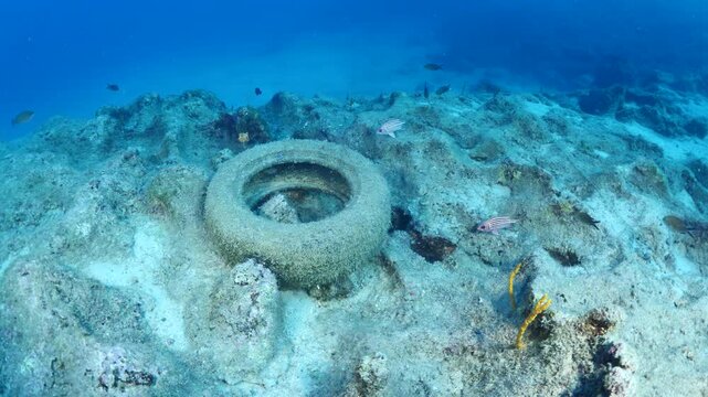 a tire wheel underwater ocean pollution plastic waste underwater