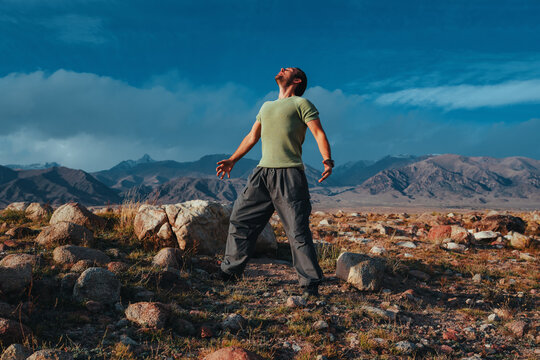 Man standing in mountains with arms open enjoying nature