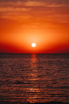 Orange sunset over calm lake with reflection on water