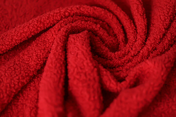 Red teddy fleece fabric draped in soft swirls and folds. Curly faux fur textile background © LadyLensArt 