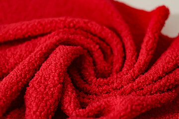 Red teddy fleece fabric draped in soft swirls and folds. Curly faux fur textile background © LadyLensArt 