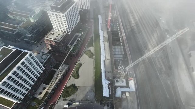 Cinematic aerial drone footage of downtown Toronto covered in dense morning fog, with sunlight piercing through the mist and creating a glowing, almost ethereal atmosphere. Modern high-rise buildings