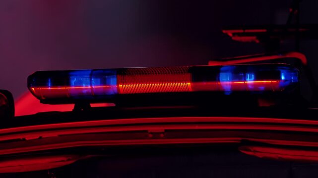 Police car roof with blue and red emergency lights flashing at night