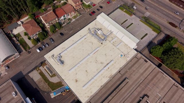 Aerial View of Industrial Roof: An elevated perspective showcasing the architectural layout of an industrial roof. The intricate structure details, offering a glimpse into building's infrastructure.