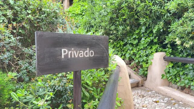 Privado sign by stairway through lush greenery, private access concept