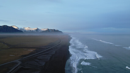 Atlanic shore black sand beach, waves crashing on nordic coastline creating natural landscape in iceland. Aerial view of beautiful icelandic scenery and arctic panoramic view. Slow motion. © DC Studio