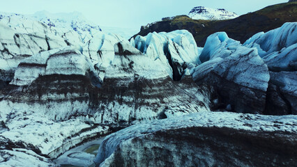 Aerial view of vatnajokull ice cap in iceland diamond shaped blocks and icebergs with crevasse. Snowy mountains landscape, icy rocks floating on frozen lake. Slow motion. © DC Studio