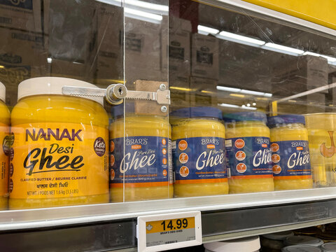 Ghee clarified butter jars locked behind protective case on shelf at No Frills grocery store. Retail scene highlighting product security and theft prevention. Aurora, Ontario, Canada, April 2026