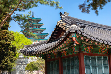 Obraz premium Close-up of ornate traditional Korean palace building with decorative painted eaves, curved tiled roof and colorful floral patterns at Gyeongbokgung Palace in Seoul, South Korea