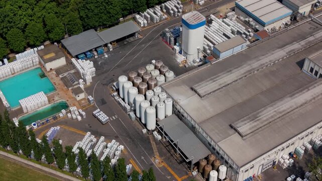 Aerial View of Industrial Plant: An expansive industrial plant is viewed from above. Featuring storage, production and distribution, showcasing the scale and organization of an industrial complex.