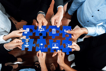 A diverse team gathers around a puzzle, using hands to symbolize collaboration, ideas, and strategies. Icons on pieces represent various concepts related to success in business. Amity © InfiniteFlow